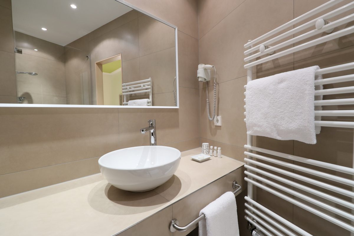 Blick auf ein Bad mit großem Waschbecken und großem Spiegel