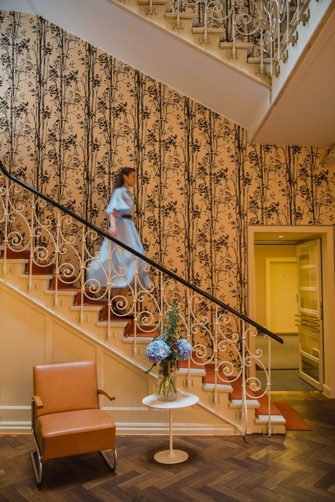 Hotelgast auf einer Treppe mit rotem Teppich