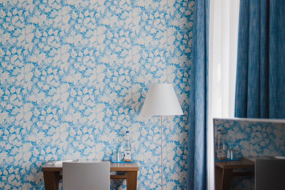 Blick auf einen Schreibtisch vor floraler Tapete 