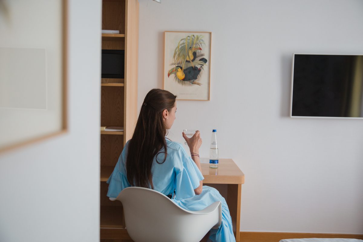 Hotelgast mit einem Wasserglas vor ei