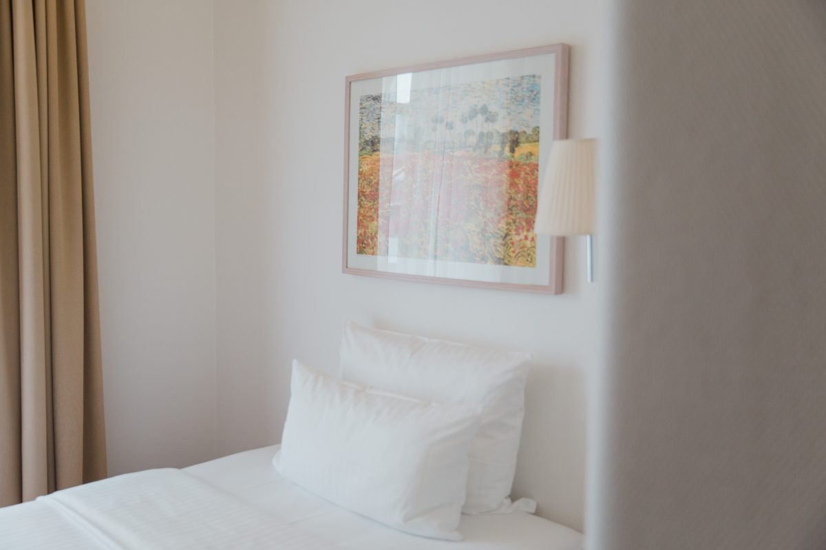 View of stylish lamp on the wall next to colorful painting