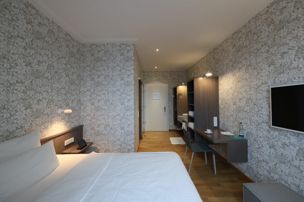 Blick auf ein Hotezimmer in geblümten Tapetendesign